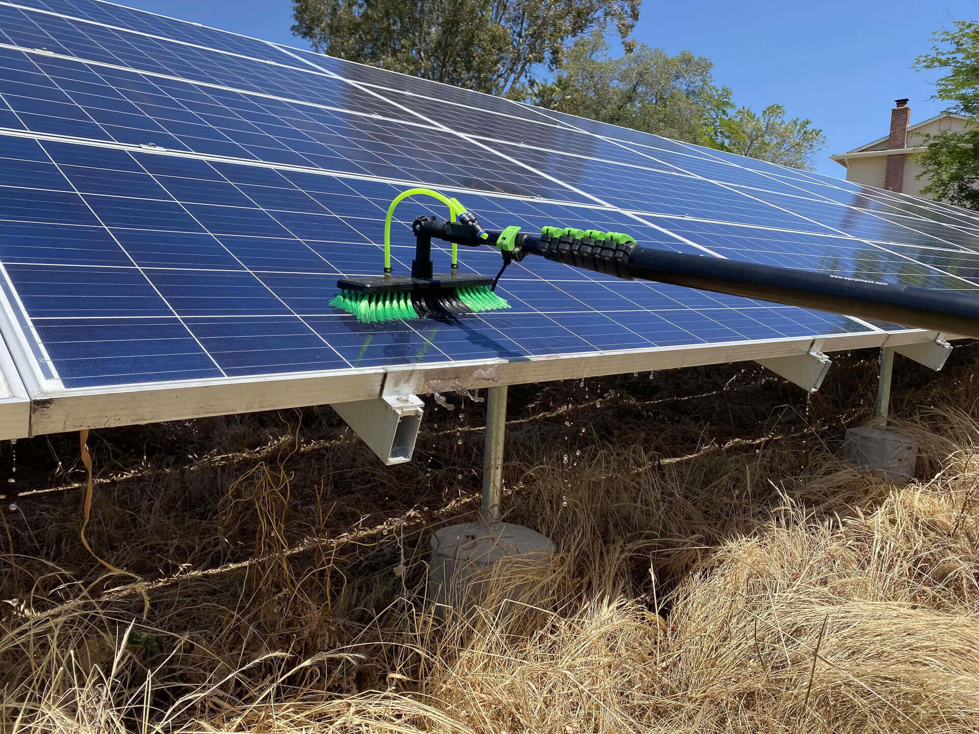 Professional solar panel cleaning equipment cleaning a ground-mounted solar array